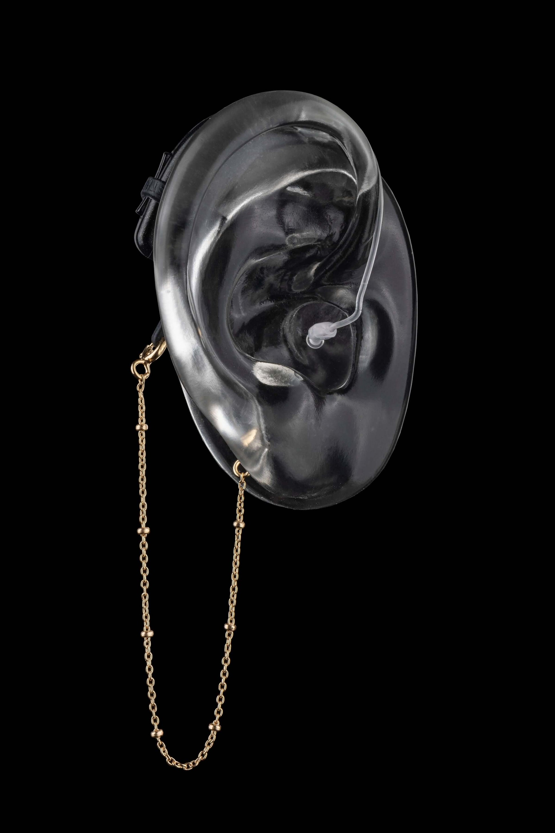 Beaded safety chain in gold for hearing aids or cochlear implants adds style and extra retention, shown on a transparent ear model.